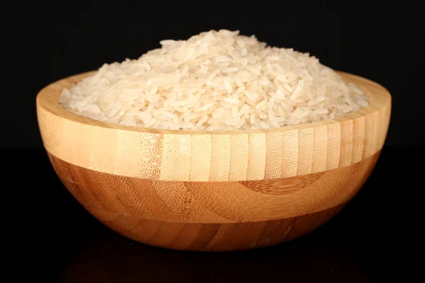 Arroz blanco pulido en cuenco de madera aislado en negro — Foto de Stock