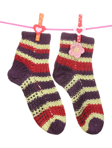 Paar gestrickte gestreifte Socken, die an einem Seil hängen, isoliert auf weiß — Stockfoto