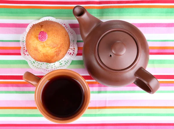 Draufsicht auf Tasse Tee und Teekanne auf bunten Tischdecken — Stockfoto