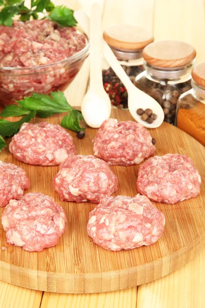 Raw meatballs with spices on wooden table — Stock Photo, Image