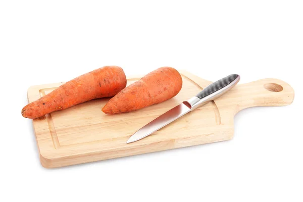 Zanahorias y cuchillo en tabla de cortar de madera aislado en blanco — Foto de Stock