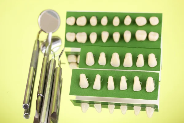 Set de herramientas dentales con dentadura postiza sobre fondo verde — Foto de Stock