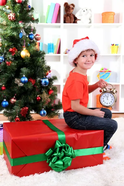 Mały chłopiec z wielkim darem i zegar w oczekiwaniu na nowy rok — Zdjęcie stockowe