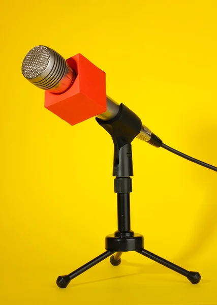 Microphone on stand on yellow background — Stock Photo, Image