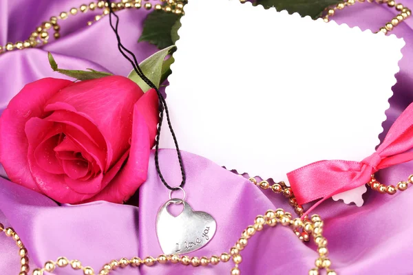 Beautiful pink rose with heart pendant Stock Photo