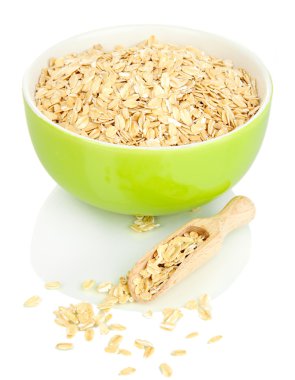 Yeşil kase yulaf gevreği üzerinde beyaz izole ahşap kepçe ile dolu