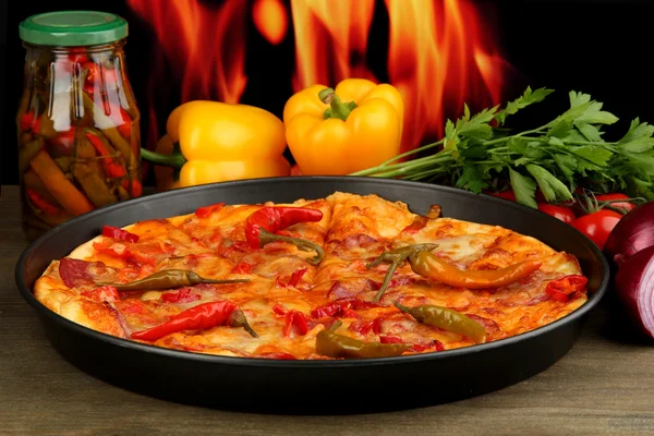 Sabrosa pizza de pepperoni en sartén con verduras sobre fondo de llama — Foto de Stock