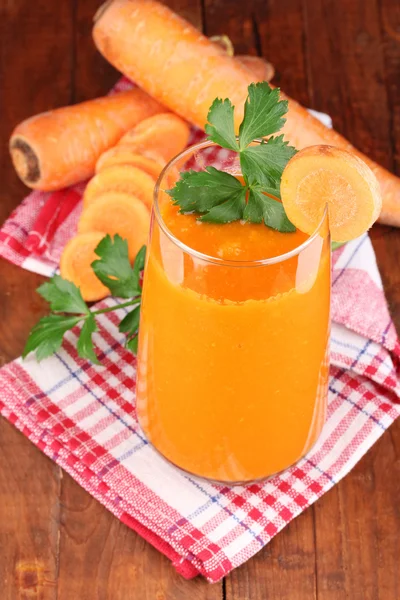 Copo de suco de cenoura na mesa de madeira — Fotografia de Stock