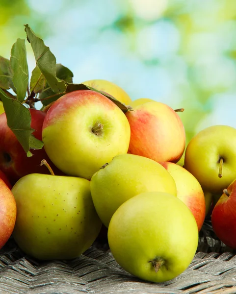 Saftiga äpplen med blad, på grön bakgrund — Stockfoto