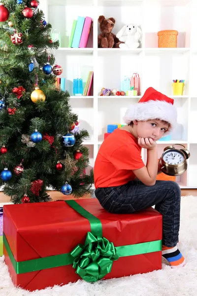 Kleine jongen met groot cadeau en klok in afwachting van het nieuwe jaar — Stockfoto