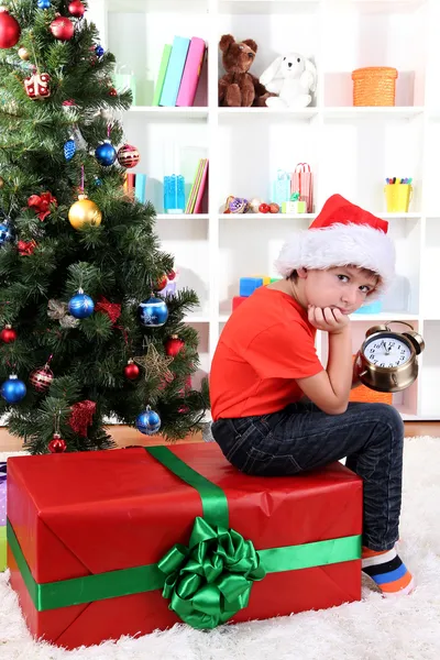 Niño pequeño con gran regalo y reloj en previsión de Año Nuevo —  Fotos de Stock