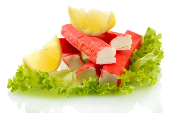 Palitos de cangrejo sobre hojas de lechuga con limón, aislados sobre blanco —  Fotos de Stock