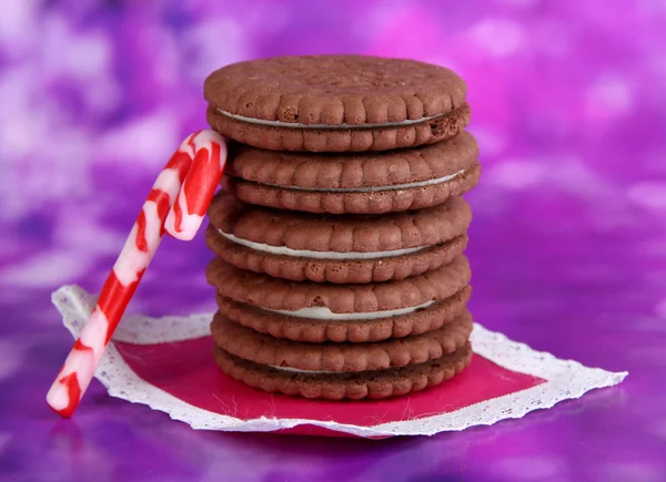 Chocolate cookies with creamy layer on purple background — Stock Photo, Image
