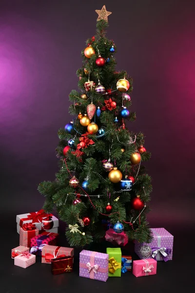 Geschmückter Weihnachtsbaum mit Geschenken auf dunklem Hintergrund — Stockfoto