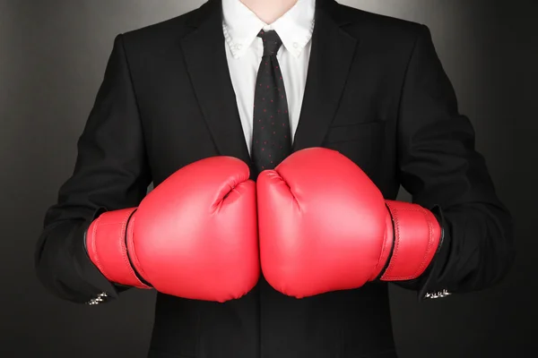 Empresário em luvas de boxe em fundo cinza — Fotografia de Stock