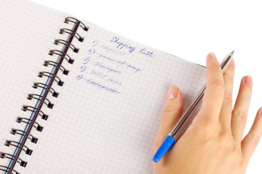 Kadının elinde alışveriş listesi olan bir defter var.