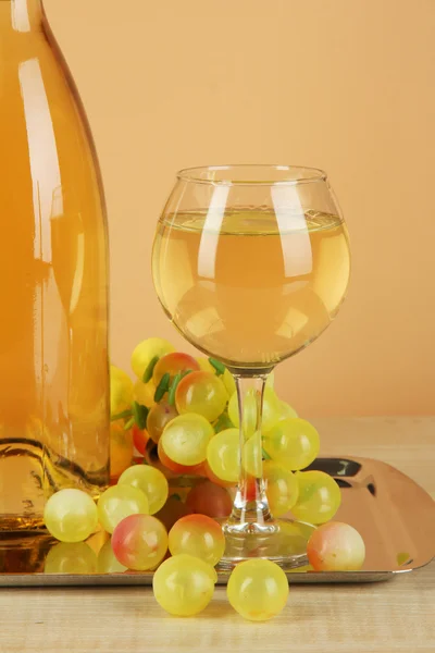 Белое вино в стакане с бутылкой на солярии на бежевом фоне — стоковое фото