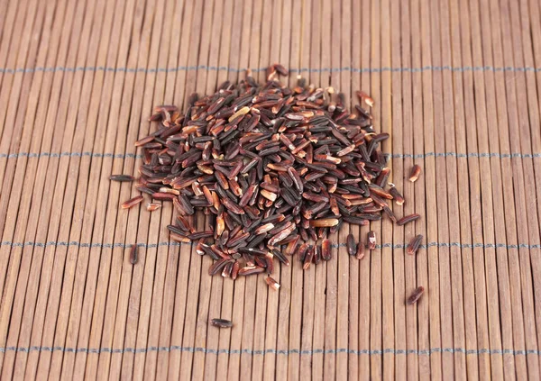 Black rice on bamboo mat — Stock Photo, Image