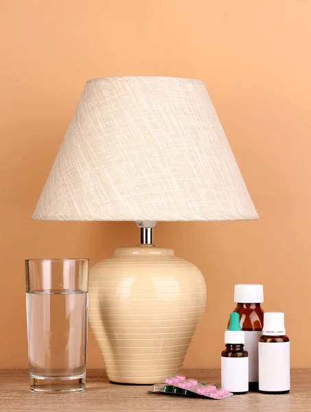 Stolní lampa a léků na béžové pozadí — Stock fotografie