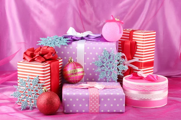 多彩的紫色、 红色和粉色礼品圣诞球与粉红色的背景上的雪花 — 图库照片