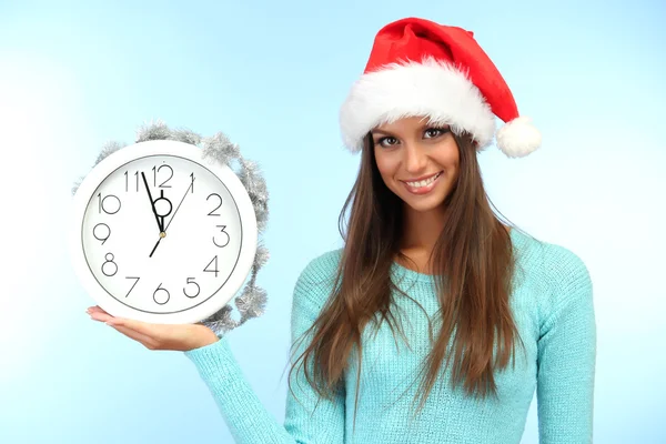 Hermosa mujer joven con reloj, sobre fondo azul — Foto de Stock