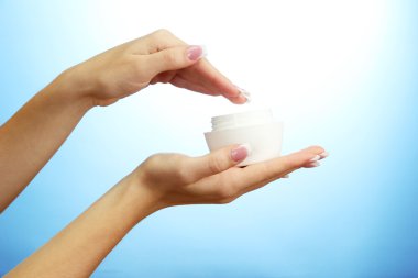 krem, mavi zemin üzerine ile güzel bir kadın el