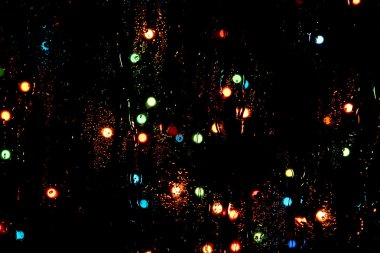 Soyut ışıklarla pencereye yağmur damlaları yağar