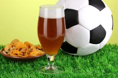 bardak bira ile çim yeşil zemin üzerine futbol topu
