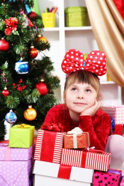 Kırmızı elbiseli festively hediyeleri çevrili rüya kız Oda dekore edilmiştir.