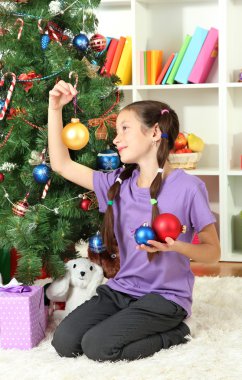 Noel ağacı süsleyen küçük kız