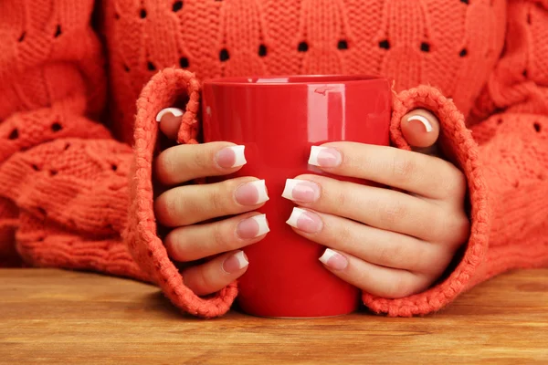 Hände halten Becher mit Heißgetränk, Nahaufnahme — Stockfoto