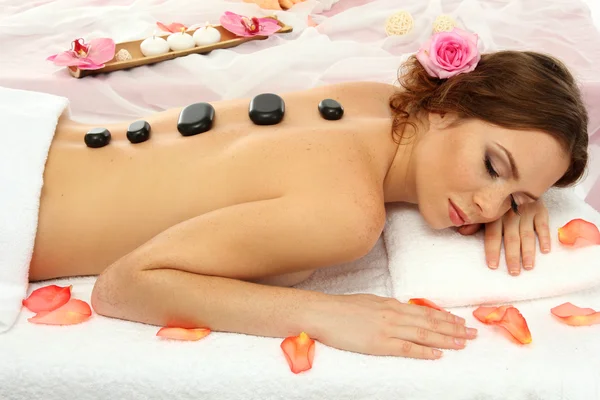 Beautiful young woman in spa salon with spa stones — Stock Photo, Image