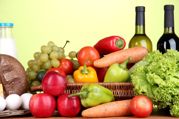 Composition with vegetables in wicker basket on green background