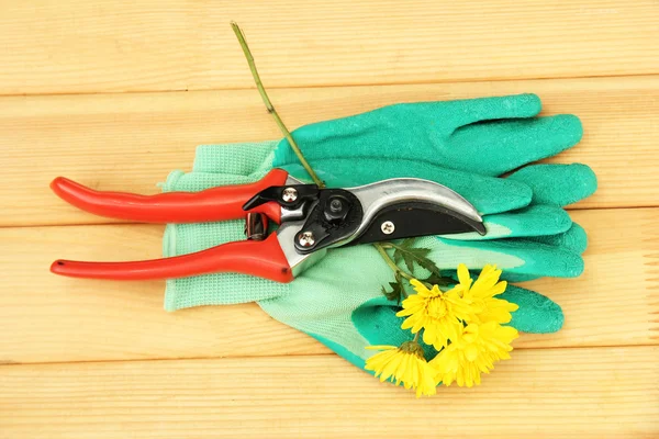 Tijeras de podar con flor sobre fondo de madera — Foto de Stock