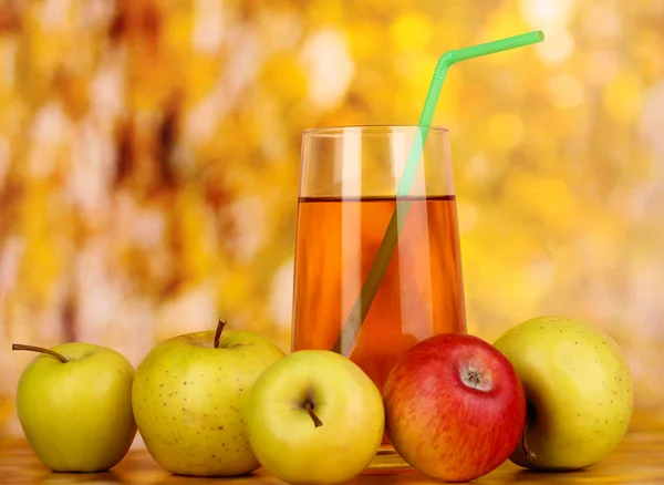 Jus de pomme utile avec des pommes autour sur fond d'automne — Photo