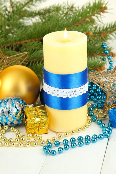 Yellow candle with christmas decoration on light background — Φωτογραφία Αρχείου