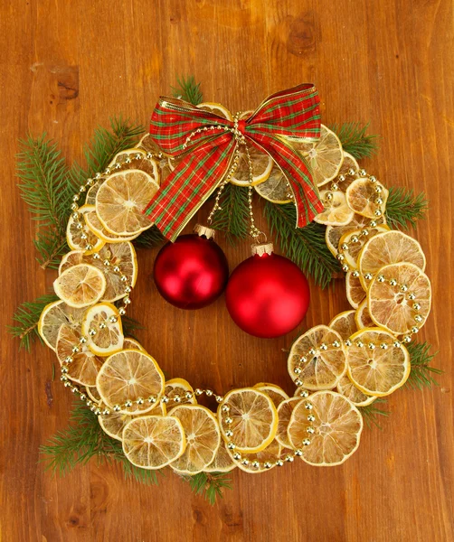 Corona de Navidad de limones secos con abeto y bolas, sobre fondo de madera —  Fotos de Stock