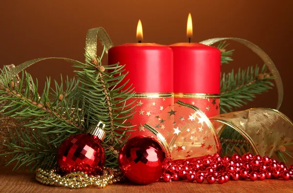 Two candles and christmas decorations, on brown background — Stock Photo, Image