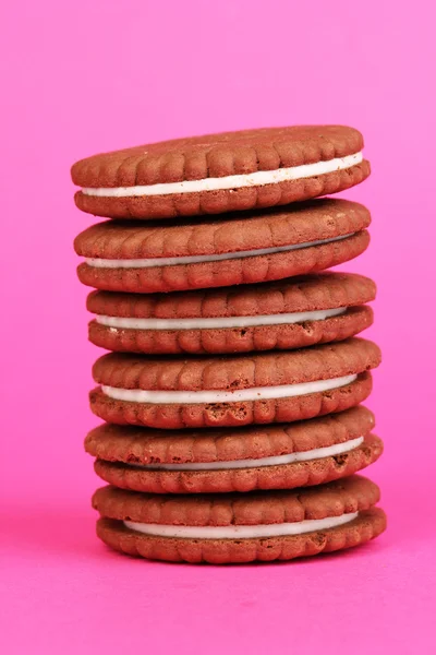 Chocolate cookies with creamy layer on pink background — Stock Photo, Image