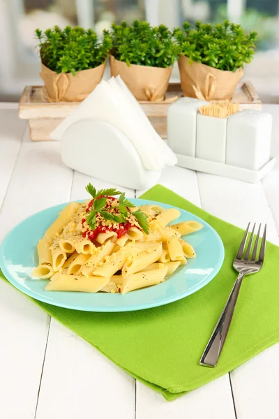 Rigatoni Nudelgericht mit Tomatensauce auf weißem Holztisch im Café — Stockfoto