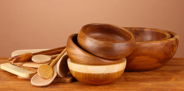 Wooden kitchen utensils on table on brown background — Stock Photo, Image