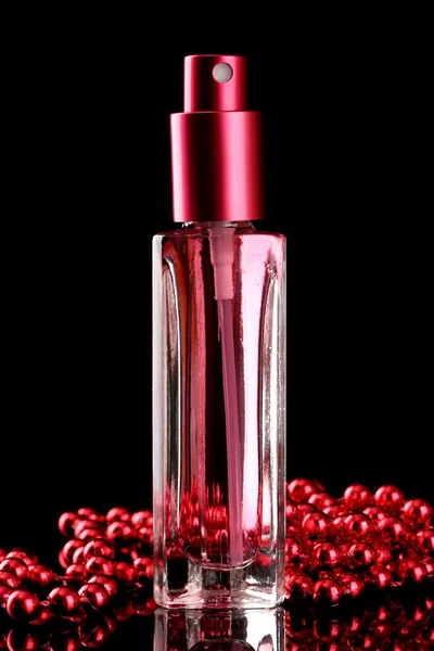 Women's perfume in beautiful bottle and beads, on black background — Stock Photo, Image