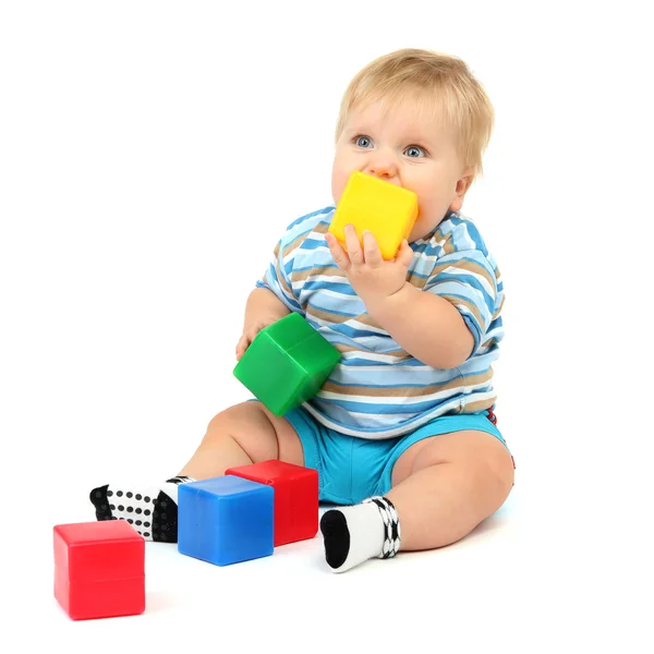 Маленький мальчик играет с разноцветными блоками — стоковое фото
