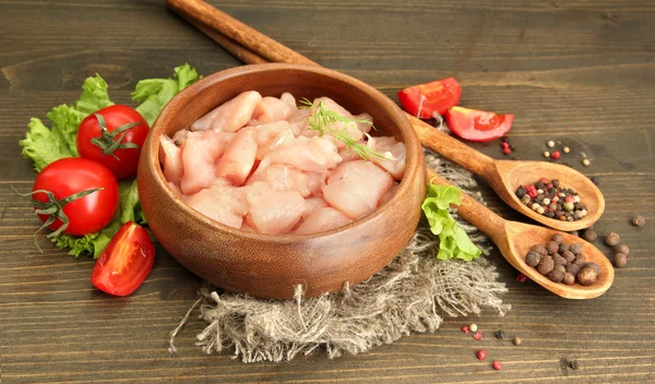 Raw chicken meat in bowl, on wooden background — Stock Photo, Image