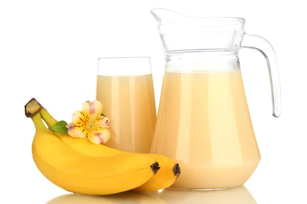 Verre plein et cruche de jus de banane et bananes isolées sur blanc — Photo