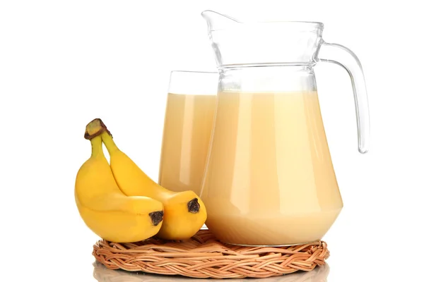 Täysi lasi ja kannu banaani mehua ja banaaneja eristetty valkoinen — kuvapankkivalokuva