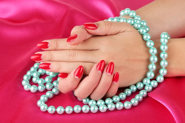 Female hands holding beads on color background Stock Image