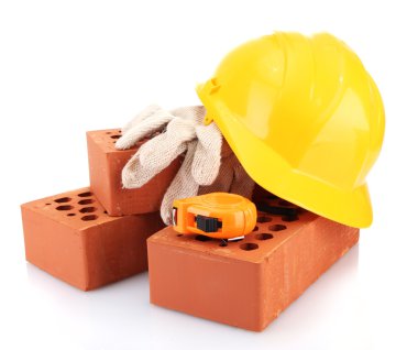 kask, rulet, tuğla ve üzerinde beyaz izole eldivenler