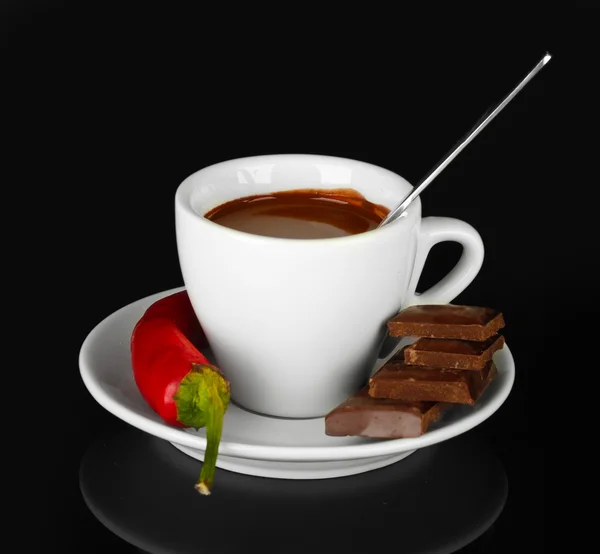 White cup with hot chocolate and chili pepper isolated on black — Stock Photo, Image