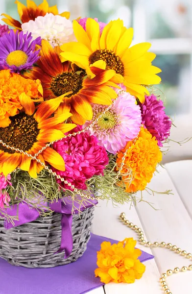 Piękny bukiet kwiatów jasny na drewnianym stole na tle okna — Zdjęcie stockowe